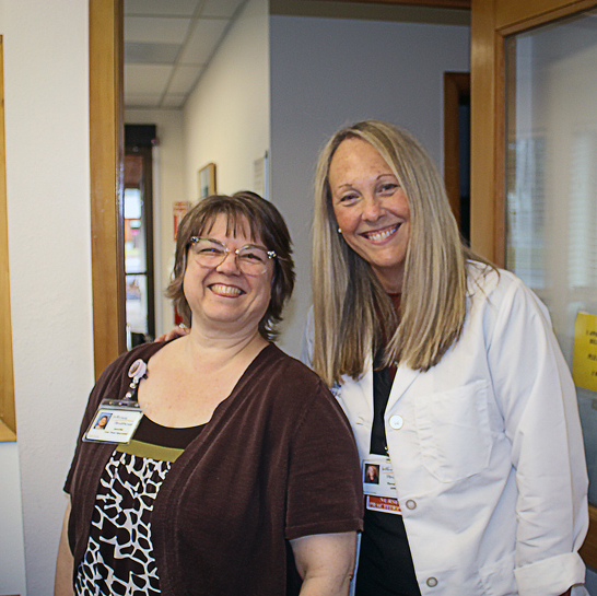 Jennifer Capehart-Mora and Genevieve “Genny” Pate stand in the office of the Jefferson Healthcare South County Clinic.