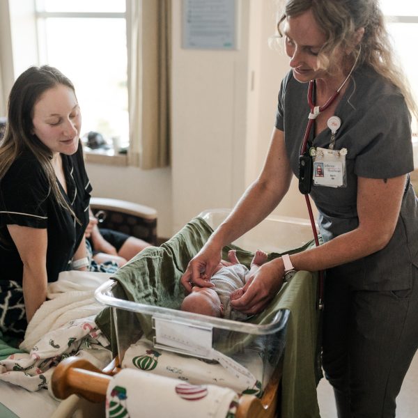 Two providers care for newborn baby.